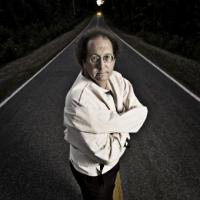 Professor Walter Sinnott-Armstrong wearing a strait jacket standing in the middle of a road